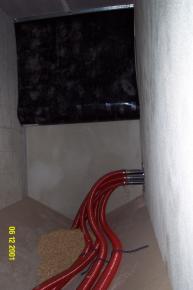 Pelletlagerraum von Innen vor der Befüllung.  Die roten Absaugschläuche und die Prallmatte an der Wand sorgen für eine optimale Pelletlagerung- und befüllung.