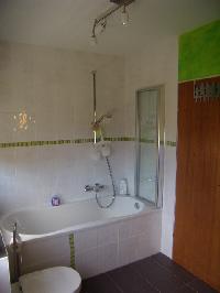 Die Badewanne mit Duschteil und Trennwand